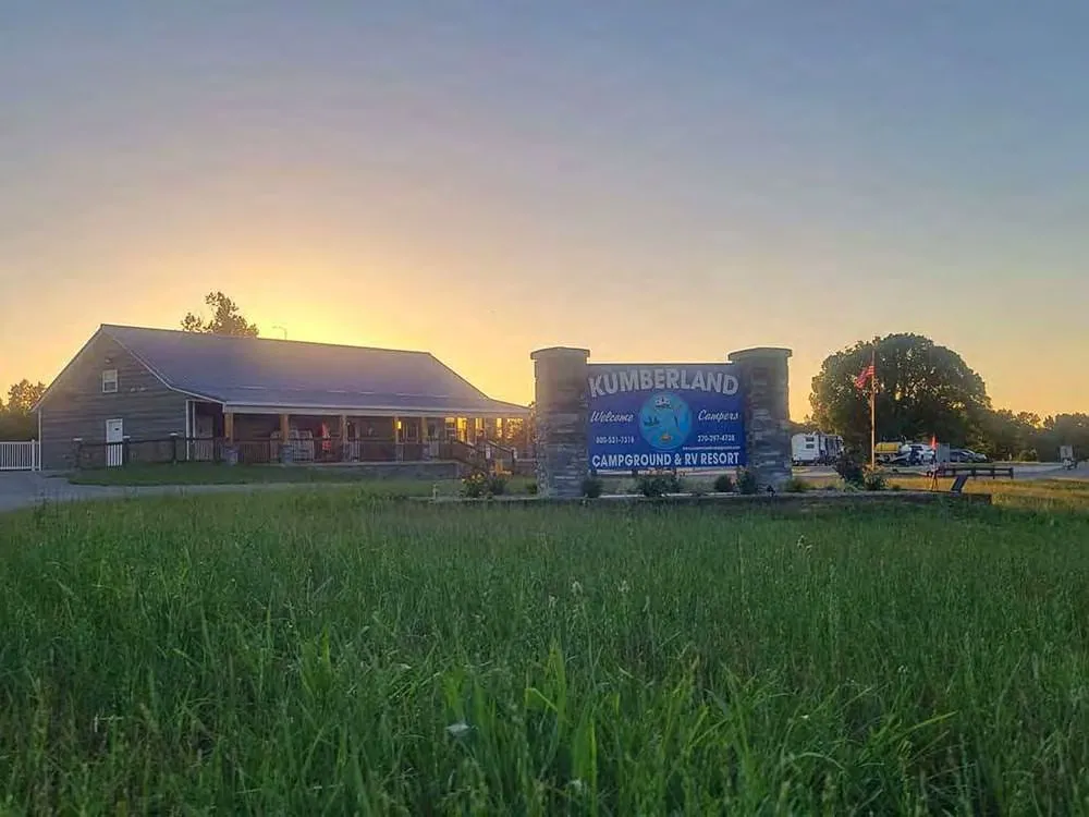 Kumberland Campground & RV Resort — entrance sign, lodge, and welcome area at sunset
