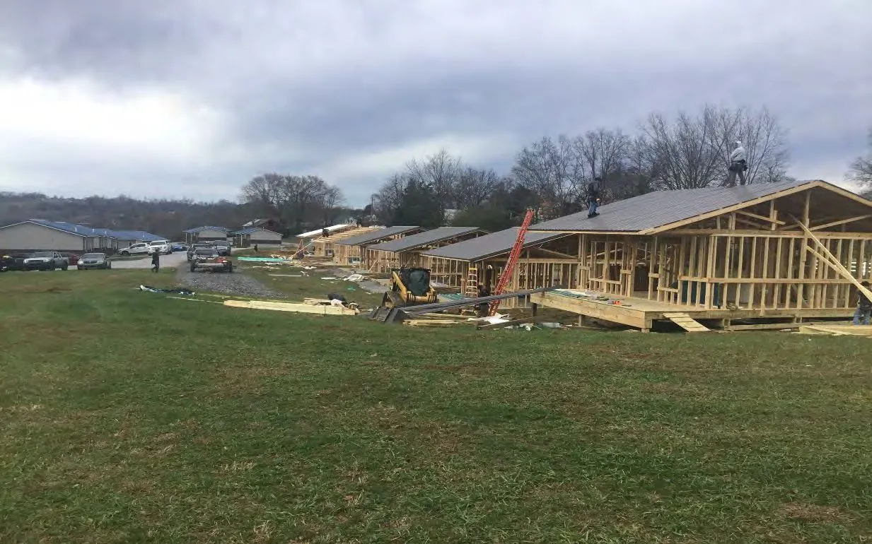 Kentucky Kabins — multiple cabin frames and construction along the clearing